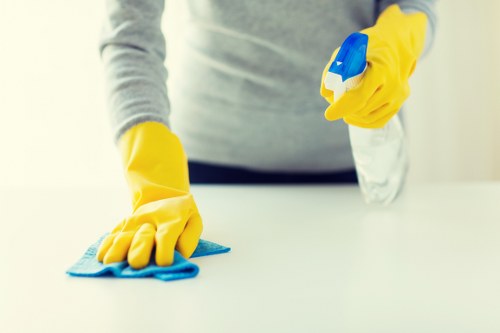 A South Kensington cleaner wearing PPE while handling cleaning products safely